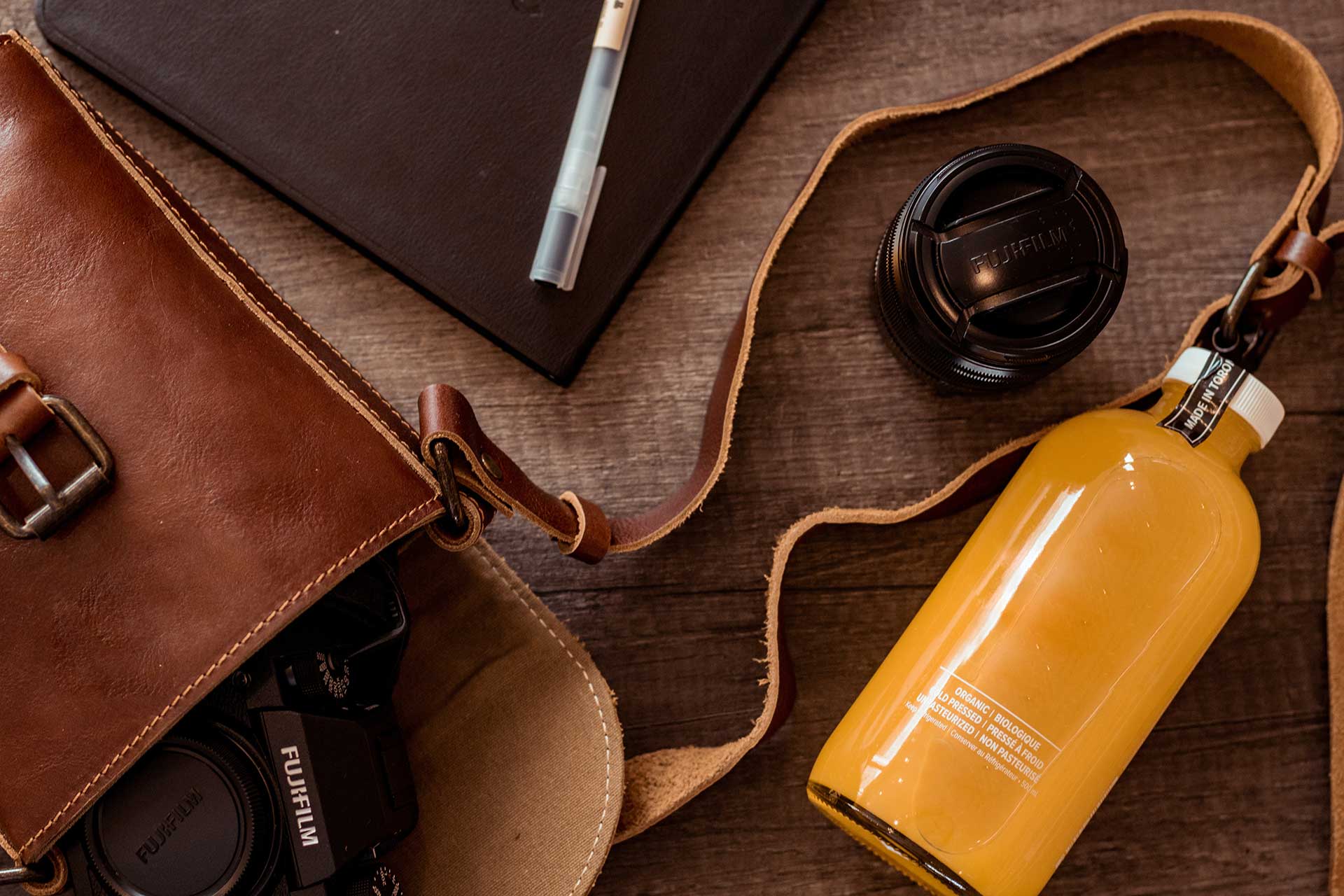 A Yellow Bottle Outside a Leather Bag